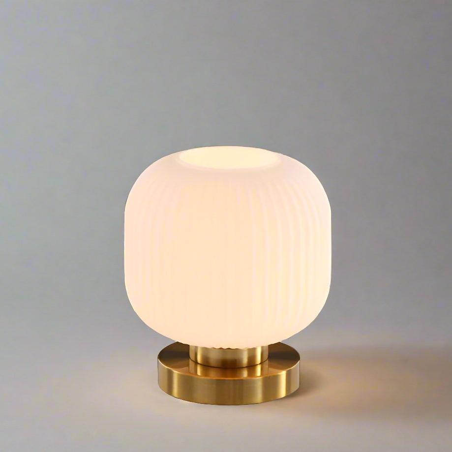 Bordlampe i ravfarvet glas med minimalistisk metalstel og varmt stemningslys