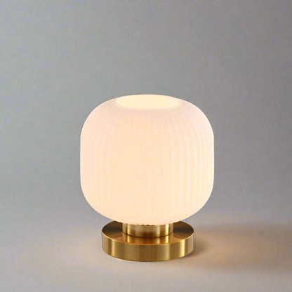 Bordlampe i ravfarvet glas med minimalistisk metalstel og varmt stemningslys