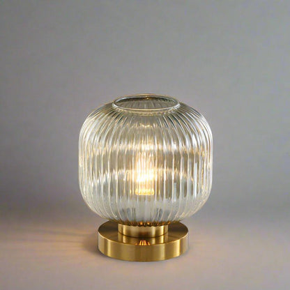 Bordlampe i ravfarvet glas med minimalistisk metalstel og varmt stemningslys