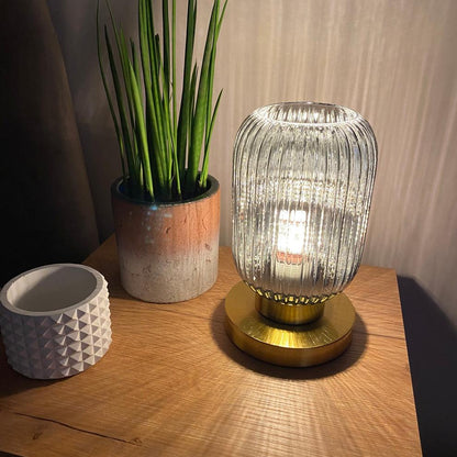 Bordlampe i ravfarvet glas med minimalistisk metalstel og varmt stemningslys