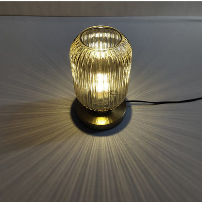 Bordlampe i ravfarvet glas med minimalistisk metalstel og varmt stemningslys