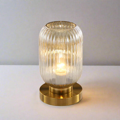 Bordlampe i ravfarvet glas med minimalistisk metalstel og varmt stemningslys
