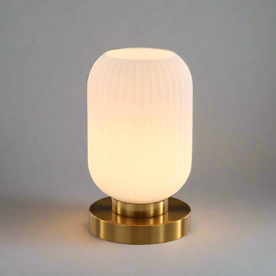 Bordlampe i ravfarvet glas med minimalistisk metalstel og varmt stemningslys