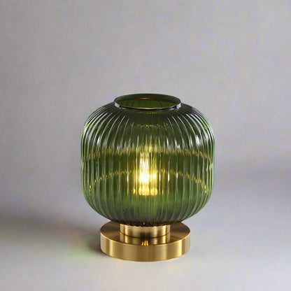 Bordlampe i ravfarvet glas med minimalistisk metalstel og varmt stemningslys
