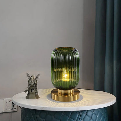 Bordlampe i ravfarvet glas med minimalistisk metalstel og varmt stemningslys