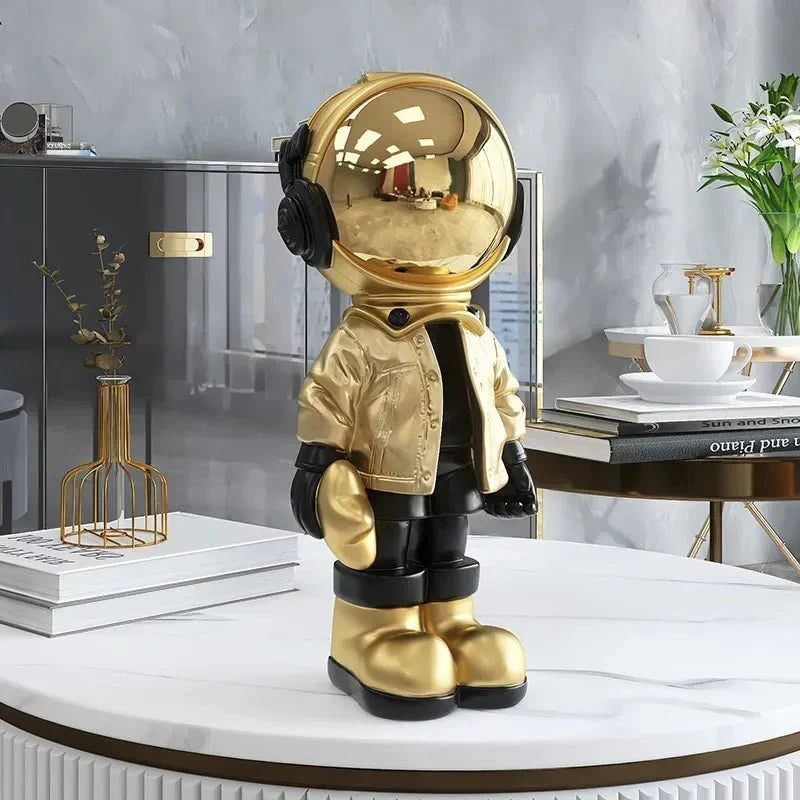 Astronautfigur i resin med gulddetaljer og rumtema