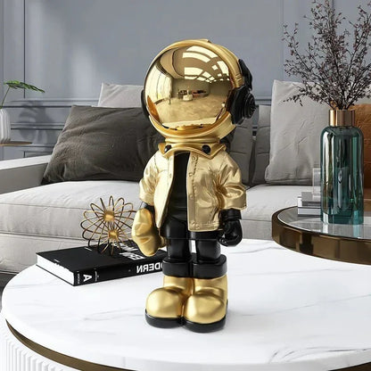 Astronautfigur i resin med gulddetaljer og rumtema