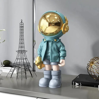 Astronautfigur i resin med gulddetaljer og rumtema