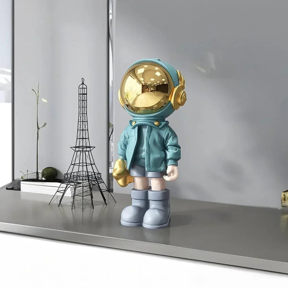 Astronautfigur i resin med gulddetaljer og rumtema