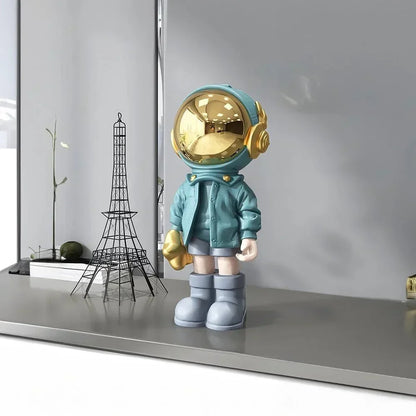 Astronautfigur i resin med gulddetaljer og rumtema