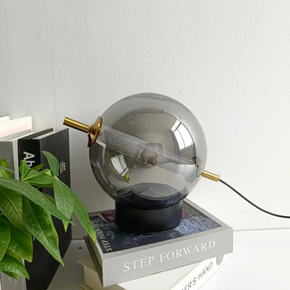Elegant bordlampe med kugleformet matteret glasskærm og metalfod